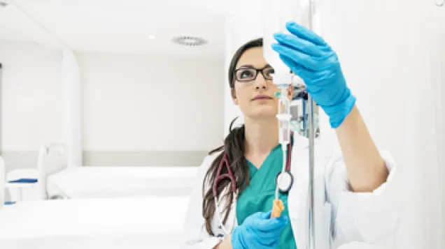 Nurse adjusting IV with antibiotics in a hospital